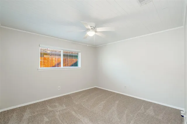 an empty room with a window and a ceiling fan