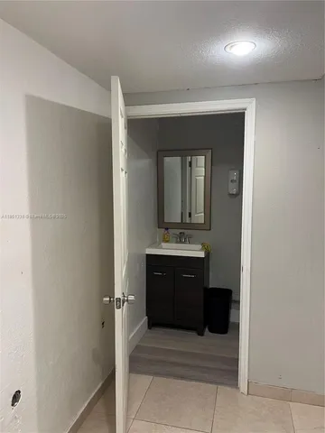 a bathroom with a toilet and a wooden floor