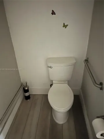 a picture of an empty room with wooden floor and white walls