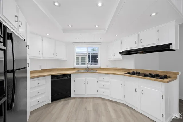 a kitchen with granite countertop white cabinets and refrigerator