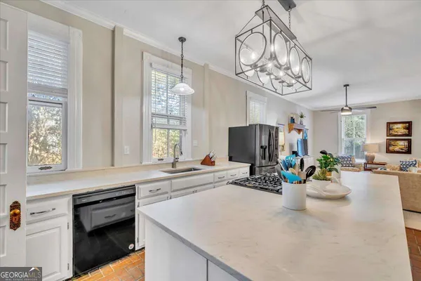 a living room with furniture kitchen view and a chandelier