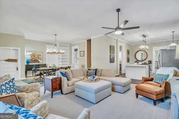 a living room with furniture dining table a chandelier and a flat screen tv