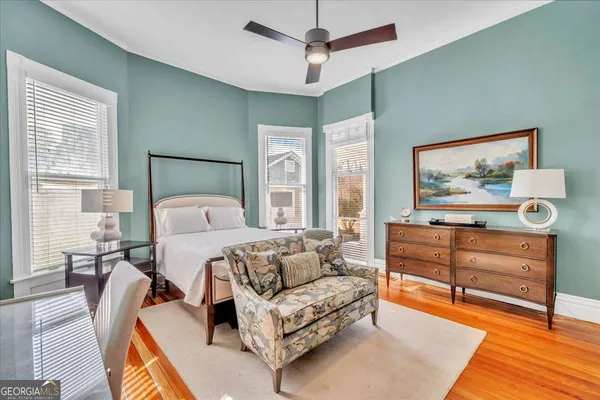 a bedroom with a large bed and wooden floor
