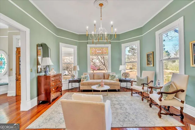 a dining room with furniture a chandelier and wooden floor