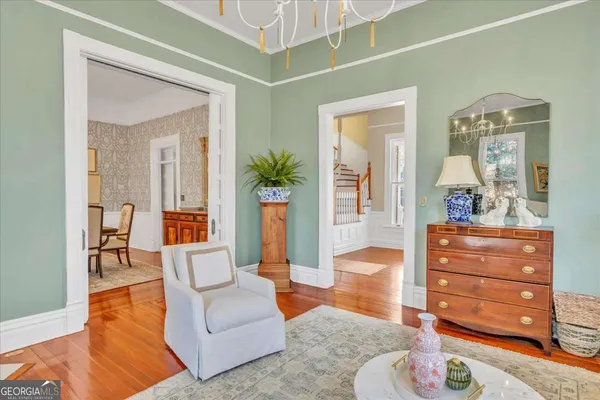 a dining room with furniture a chandelier and wooden floor