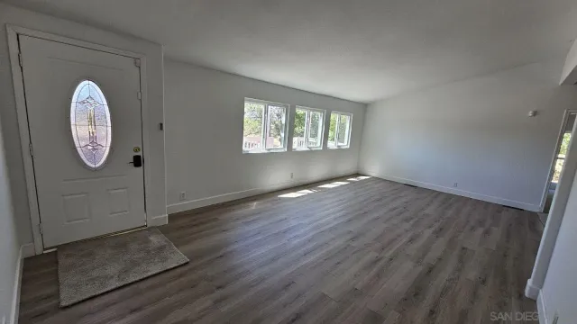 an empty room with wooden floor and a window