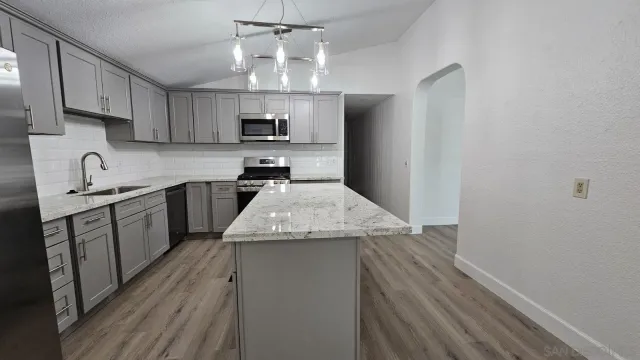 a kitchen with stainless steel appliances granite countertop a sink stove and refrigerator