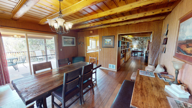315 Abbey Road Moab, UT 84532 - Photo 36 of 46 Dining room with wooden walls, dark wood-style flooring, suspended lighting, and a wood ceiling with exposed beams