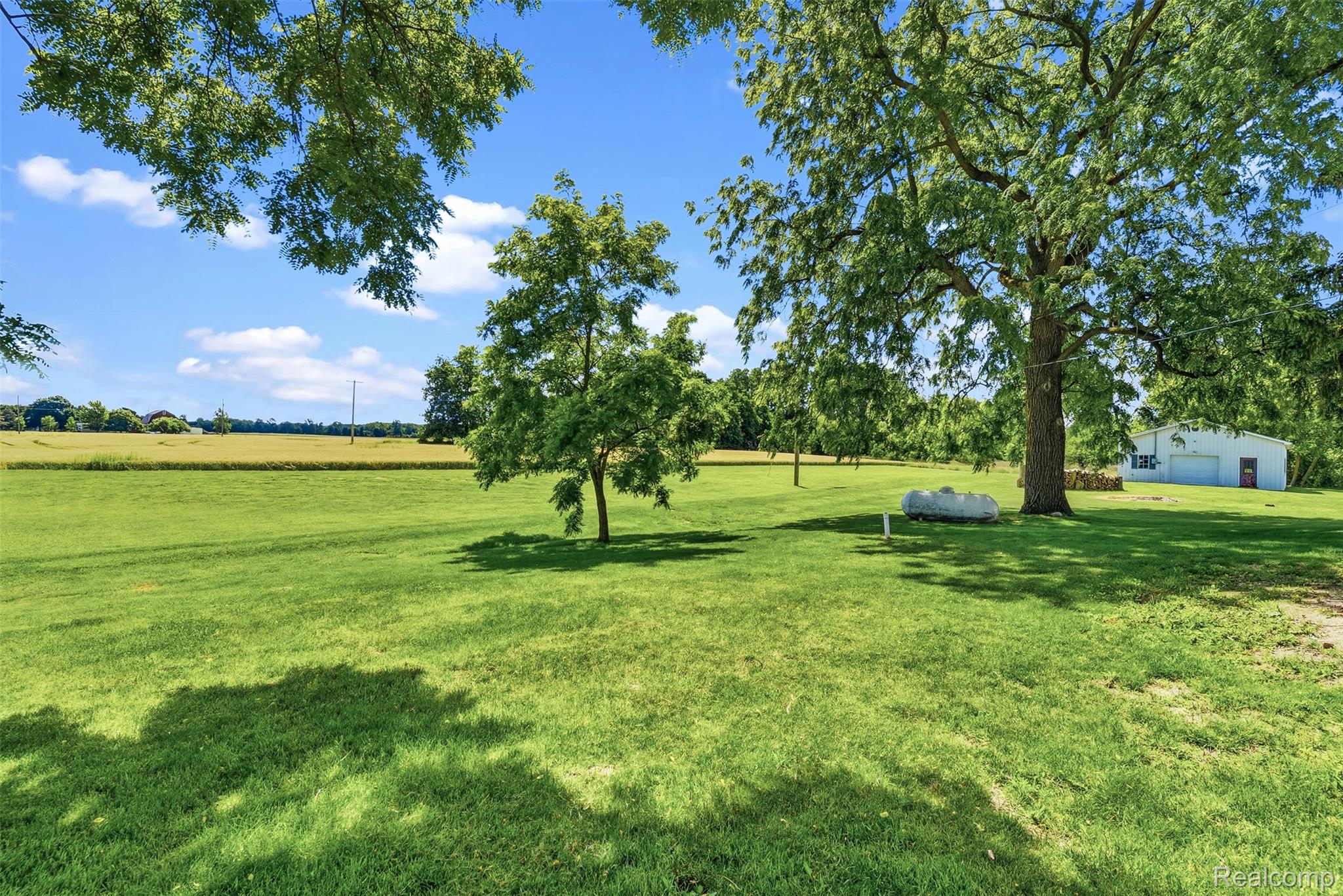 5843 West Dewey Road Owosso, MI 48867 - Photo 39 of 58 Expansive green lawn with mature trees providing dappled sunlight