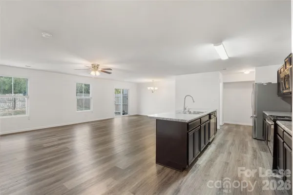 a view of a kitchen with a sink and wooden floor