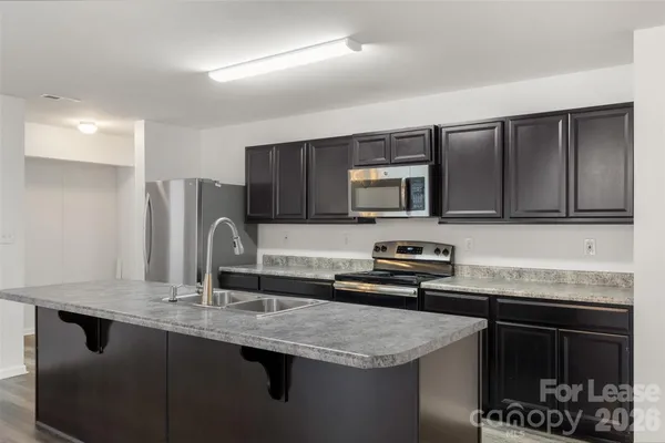 a kitchen with stainless steel appliances granite countertop a sink stove and microwave