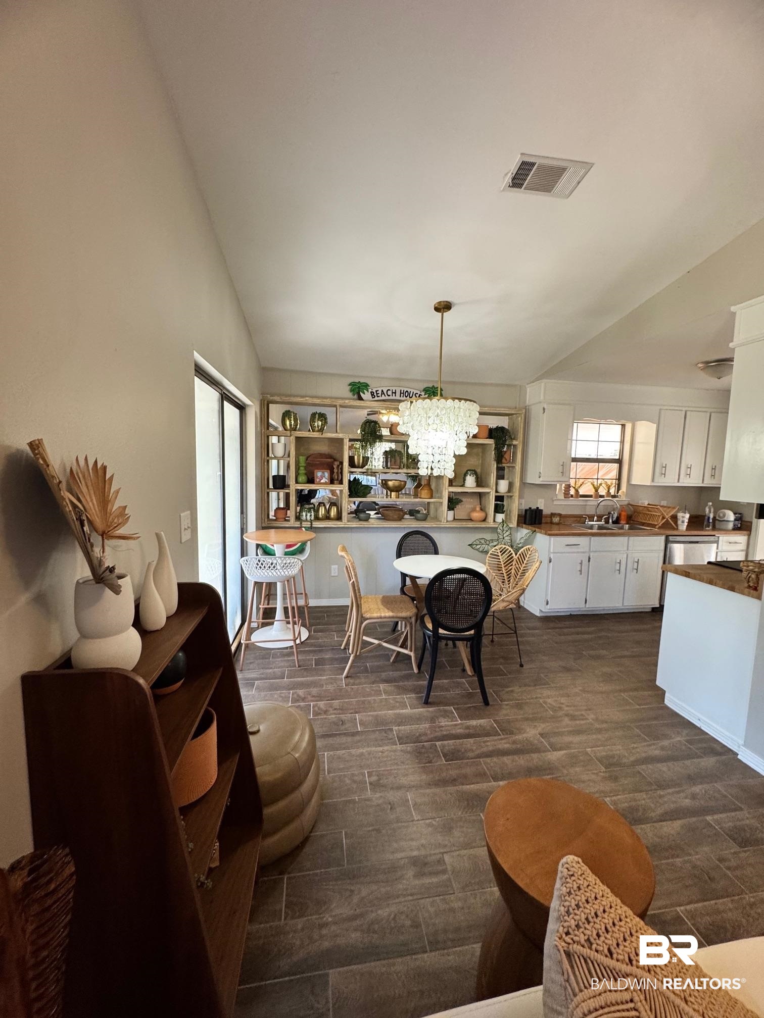 1434 Ridgewood Drive Lillian, AL 36549 - Photo 15 of 45 Dining area featuring lofted ceiling and a notable chandelier