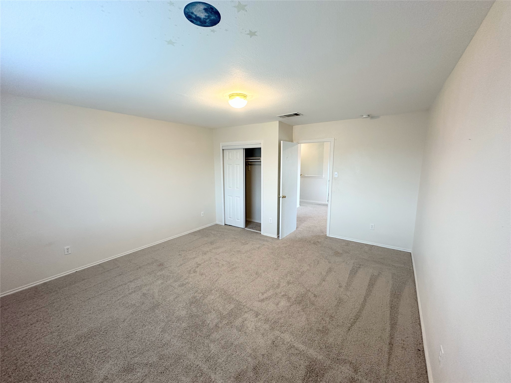 12929 Waynespur Lane Elgin, TX 78621 - Photo 14 of 20 The property features a spacious room with light-colored carpeting, white walls, and a ceiling light fixture