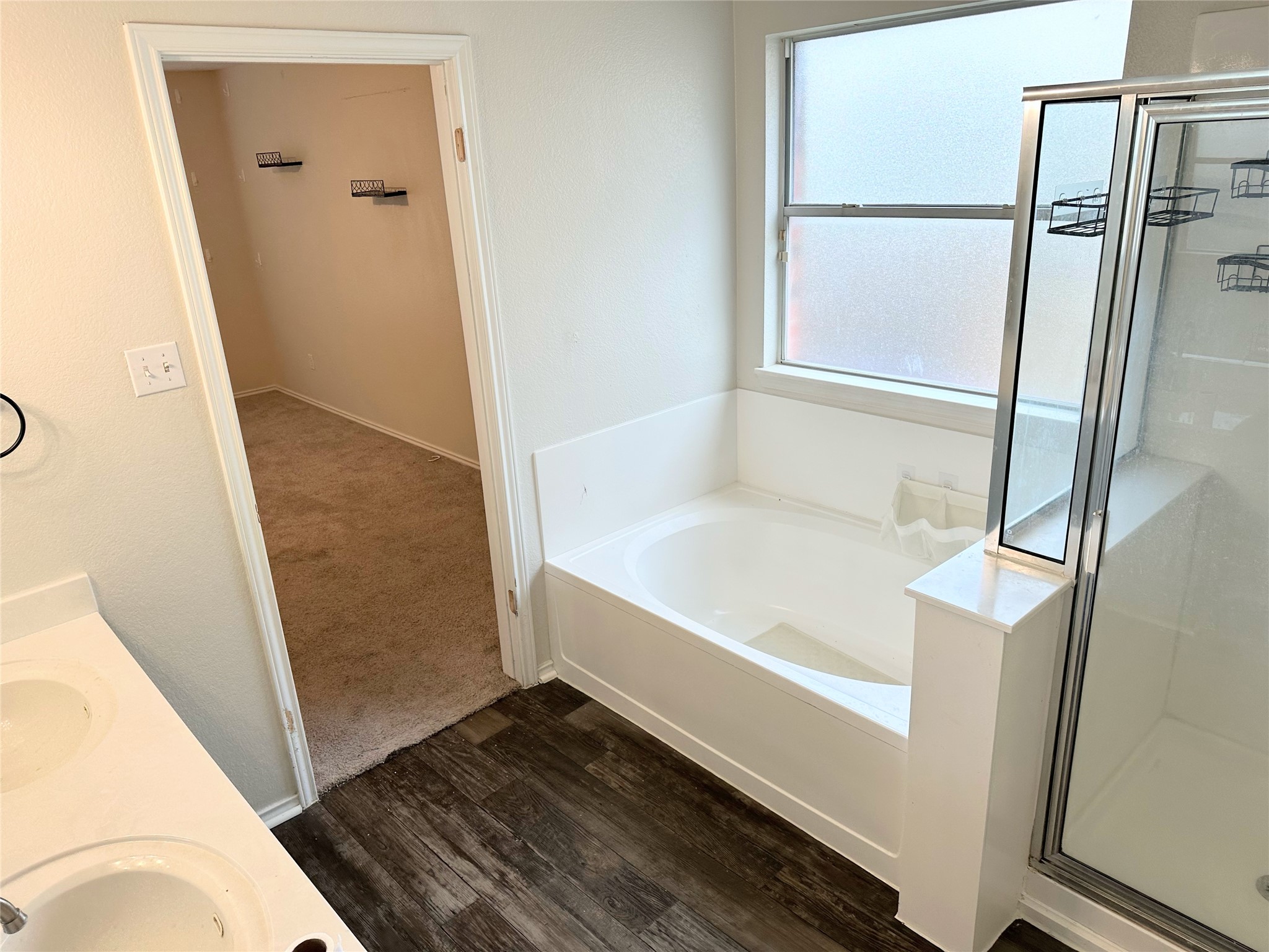 12929 Waynespur Lane Elgin, TX 78621 - Photo 10 of 20 The bathroom features a white vanity with dual sinks, a built-in bathtub, and a glass-enclosed shower