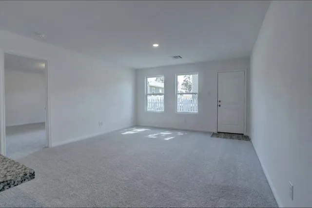 an empty room with windows and closet