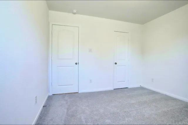 a view of a house with a small yard and wooden fence