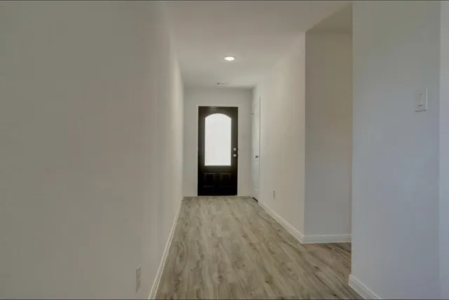 a view of a room with wooden floor and white wall