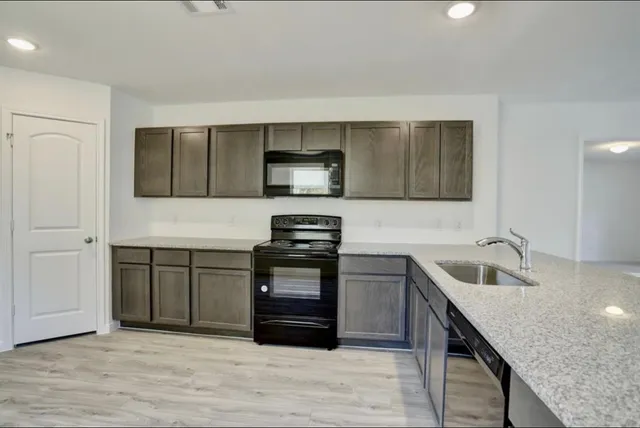 a kitchen with granite countertop a sink and wooden cabinets