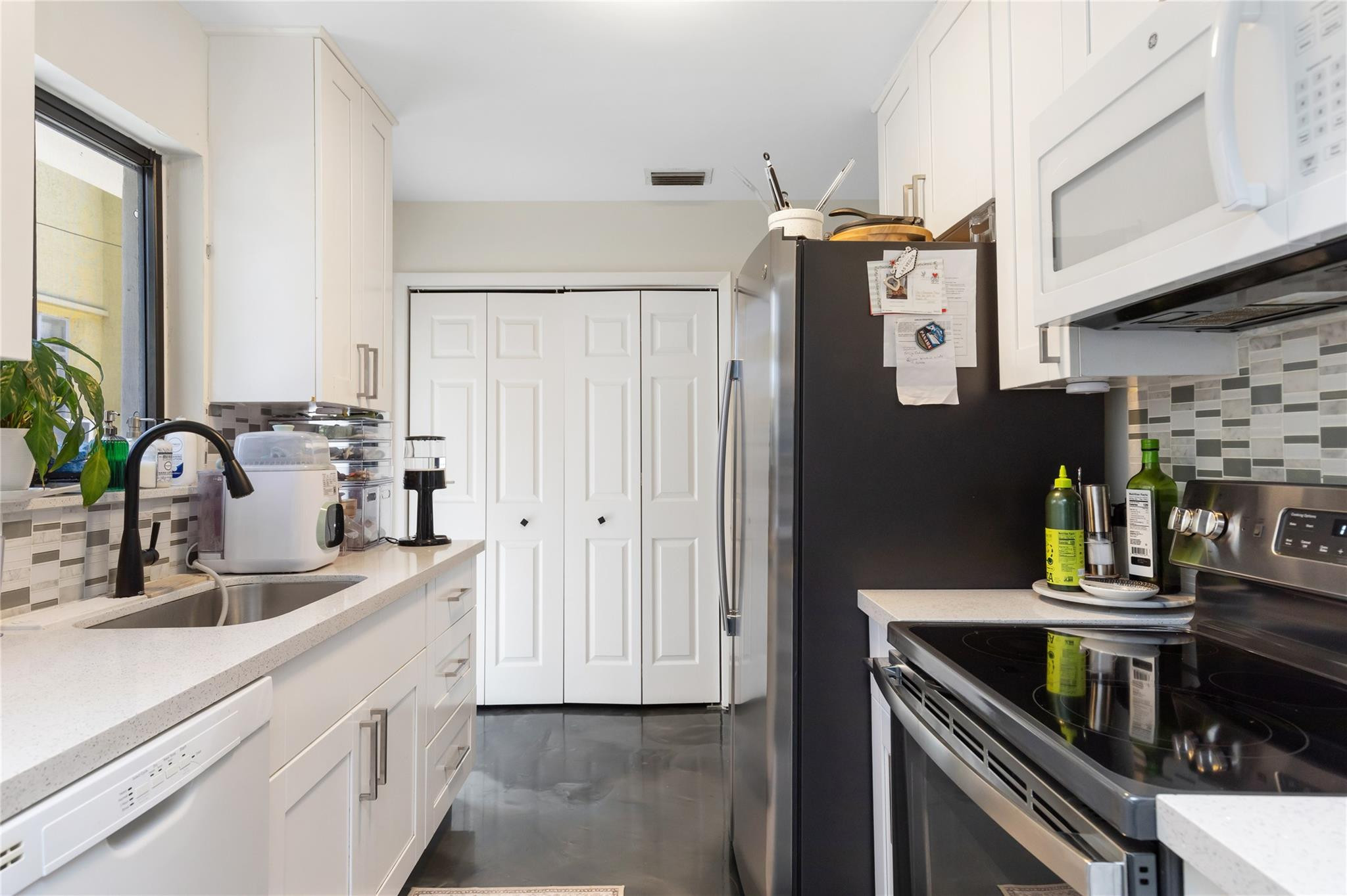 3461 Southwest 24th Street Miami, FL 33145 - Photo 14 of 55 a kitchen with stainless steel appliances a sink a stove and cabinets