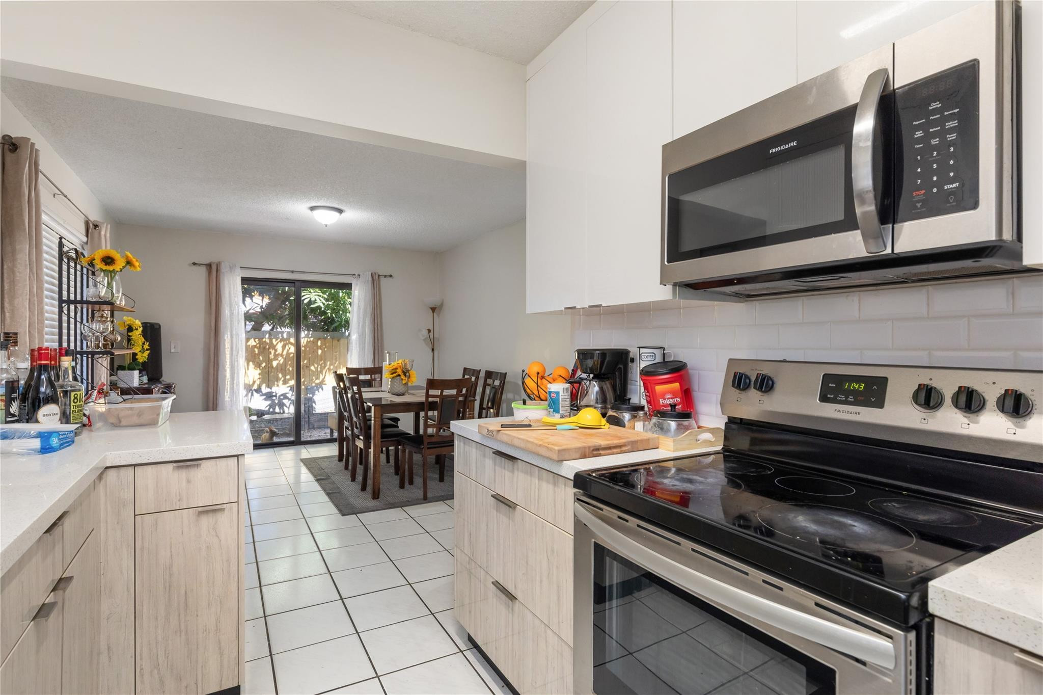3461 Southwest 24th Street Miami, FL 33145 - Photo 37 of 55 a kitchen with a stove a microwave and wooden cabinets