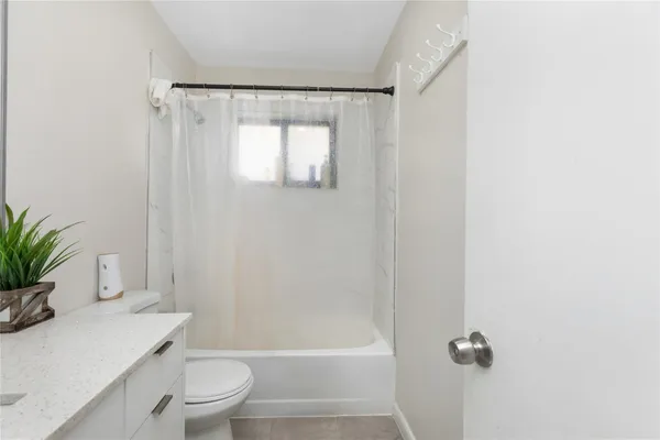 a bathroom with a toilet and a shower curtain