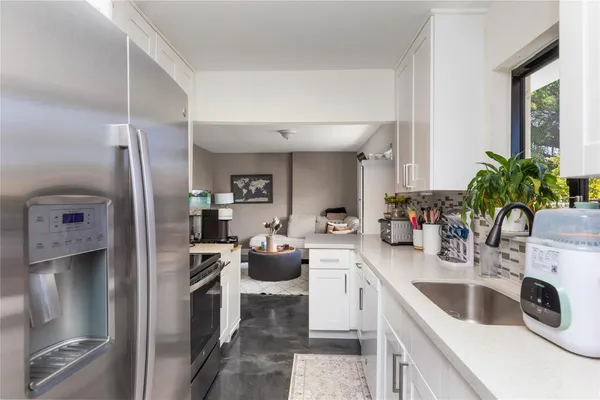 a kitchen with stainless steel appliances a sink a stove and cabinets