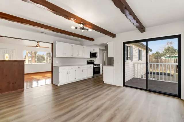 a view of a big room with wooden floor and windows
