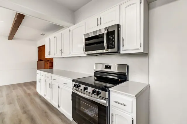 a kitchen with stainless steel appliances a stove a microwave and cabinets
