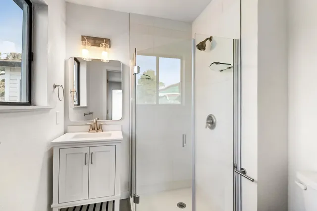 a bathroom with a double vanity sink mirror and shower