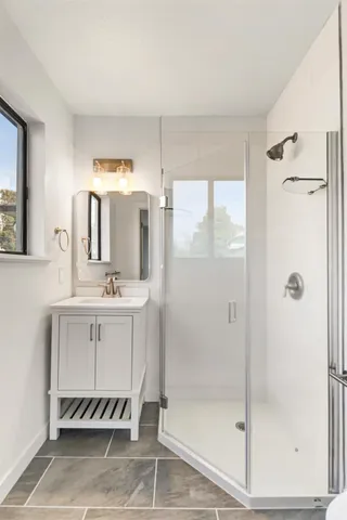 a bathroom with a shower sink and mirror