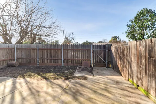 a view of a backyard with wooden fence