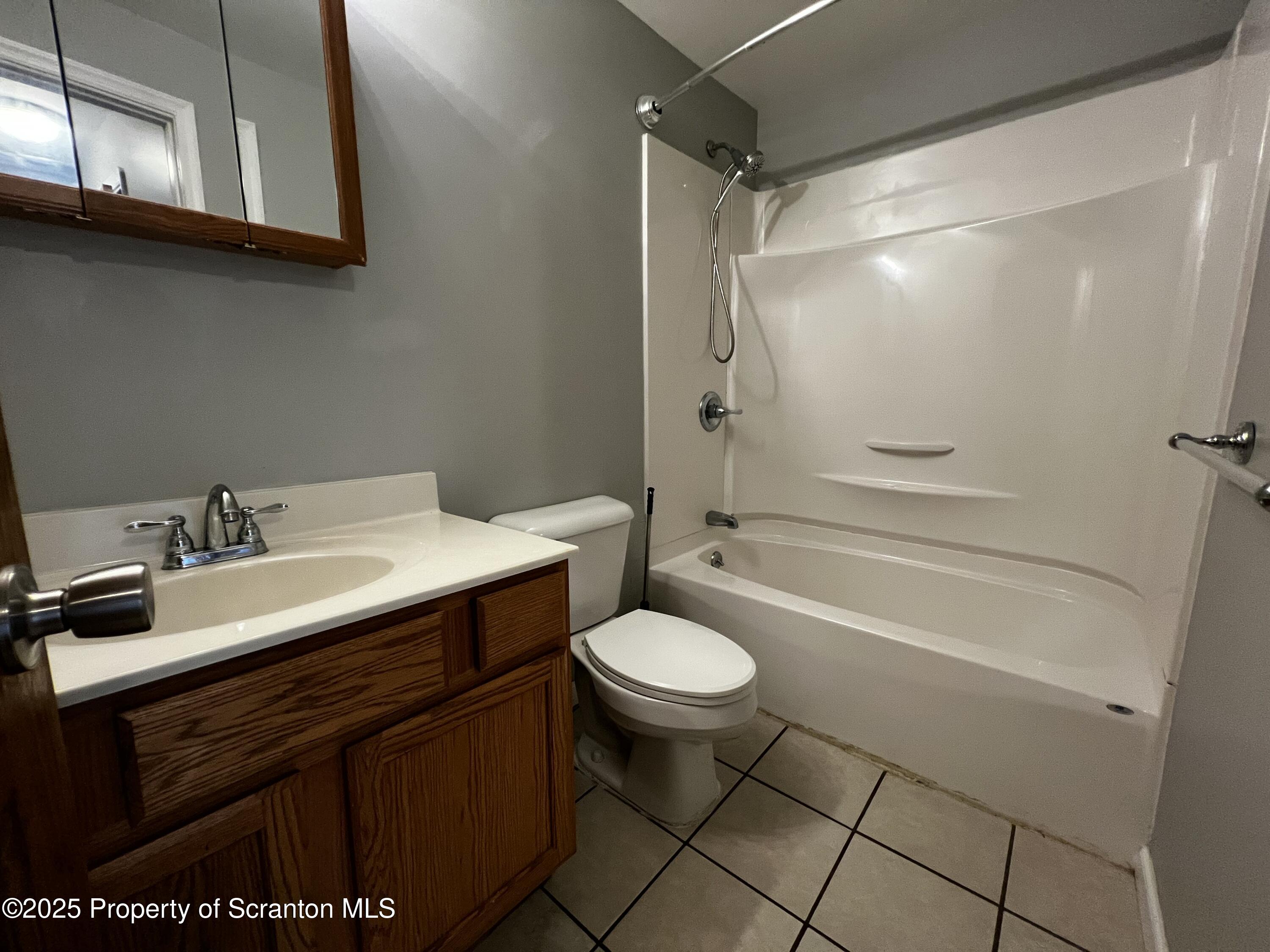 205 North Washington Avenue, Unit 2 Scranton, PA 18503 - Photo 4 of 12 a bathroom with a sink toilet a mirror and shower