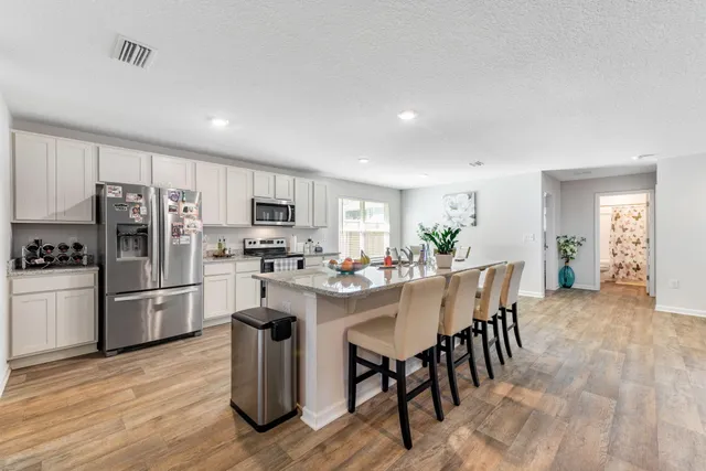 a kitchen with refrigerator and chairs