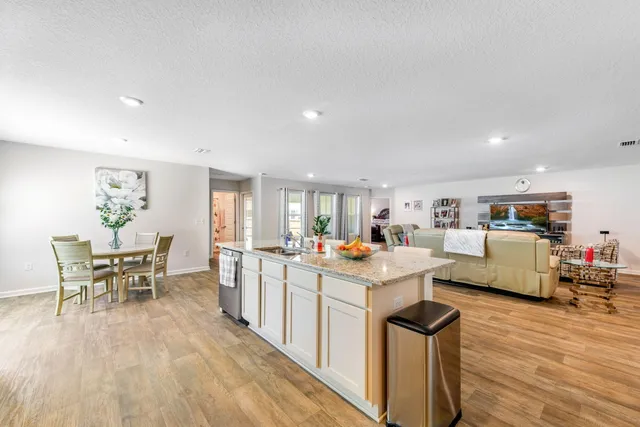 a large white kitchen with lots of counter space and refrigerator