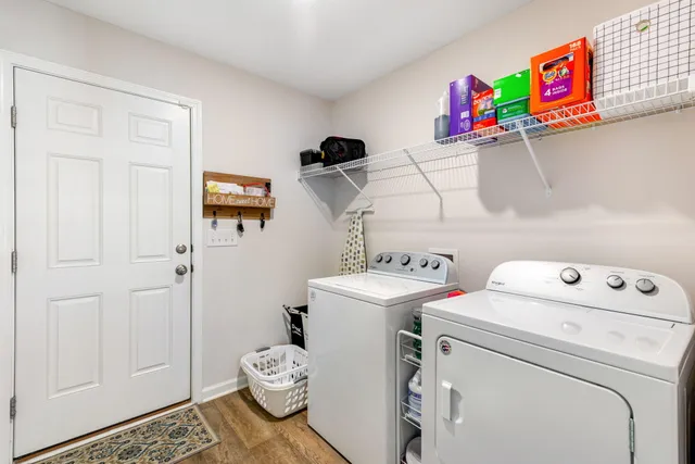 a living room with stainless steel appliances a table and chairs in it