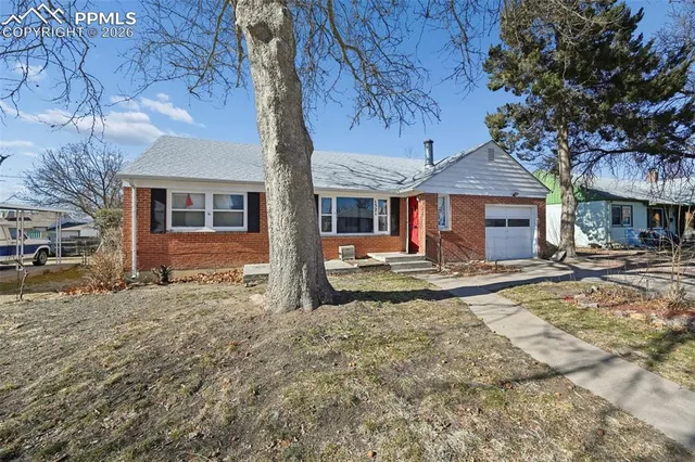 a view of a old house with a yard covered in snow