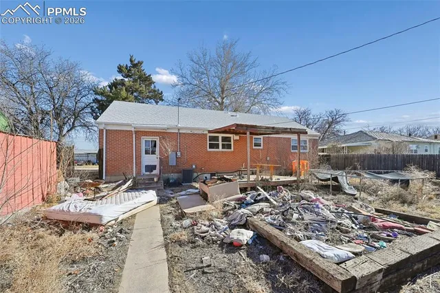 a front view of a house with yard outdoor seating and covered with trees