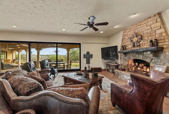 a living room with furniture fireplace and a large window