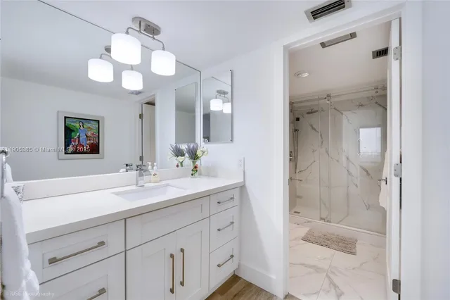 a bathroom with a granite countertop sink mirror and shower