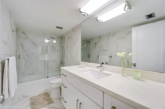 a bathroom with a sink toilet double vanity and shower