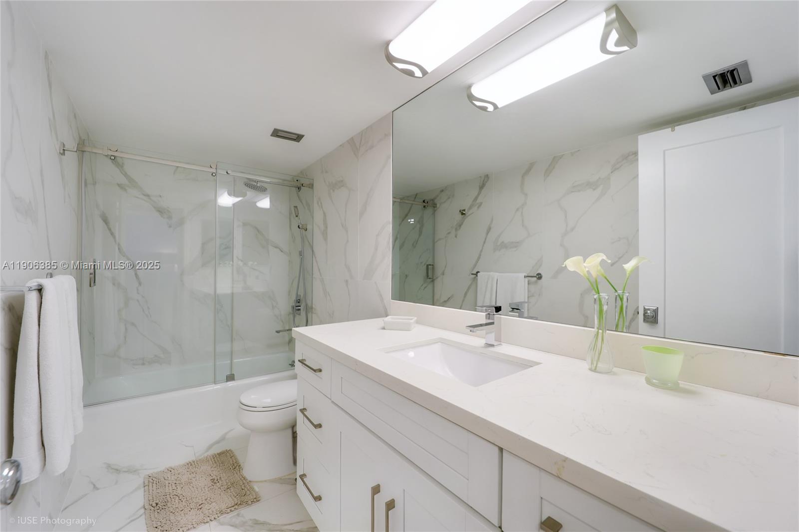 881 Ocean Drive, Unit 5D Key Biscayne, FL 33149 - Photo 14 of 18 a bathroom with a sink toilet double vanity and shower