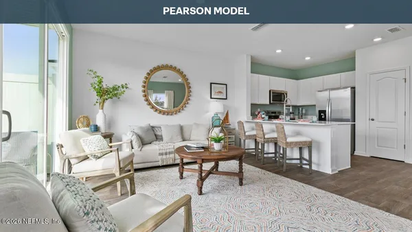 a living room with furniture a clock and a view of kitchen