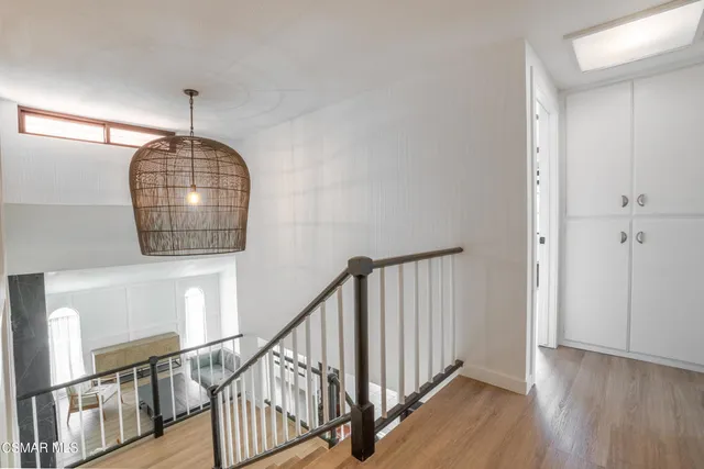 a view of a hallway with wooden floor and stairs