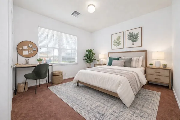 a bedroom with a bed a table and chair