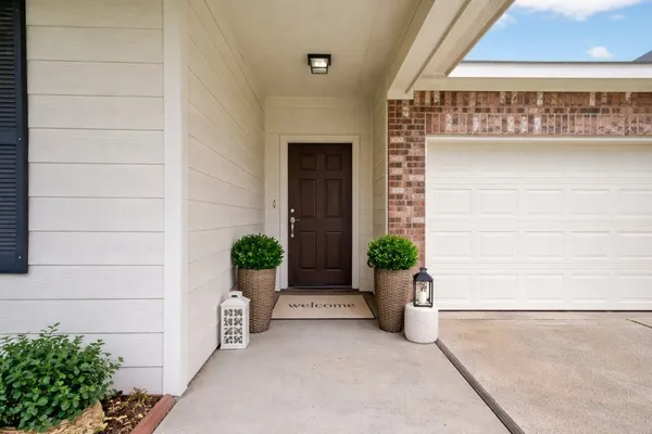 a view of house with potted plant and garage