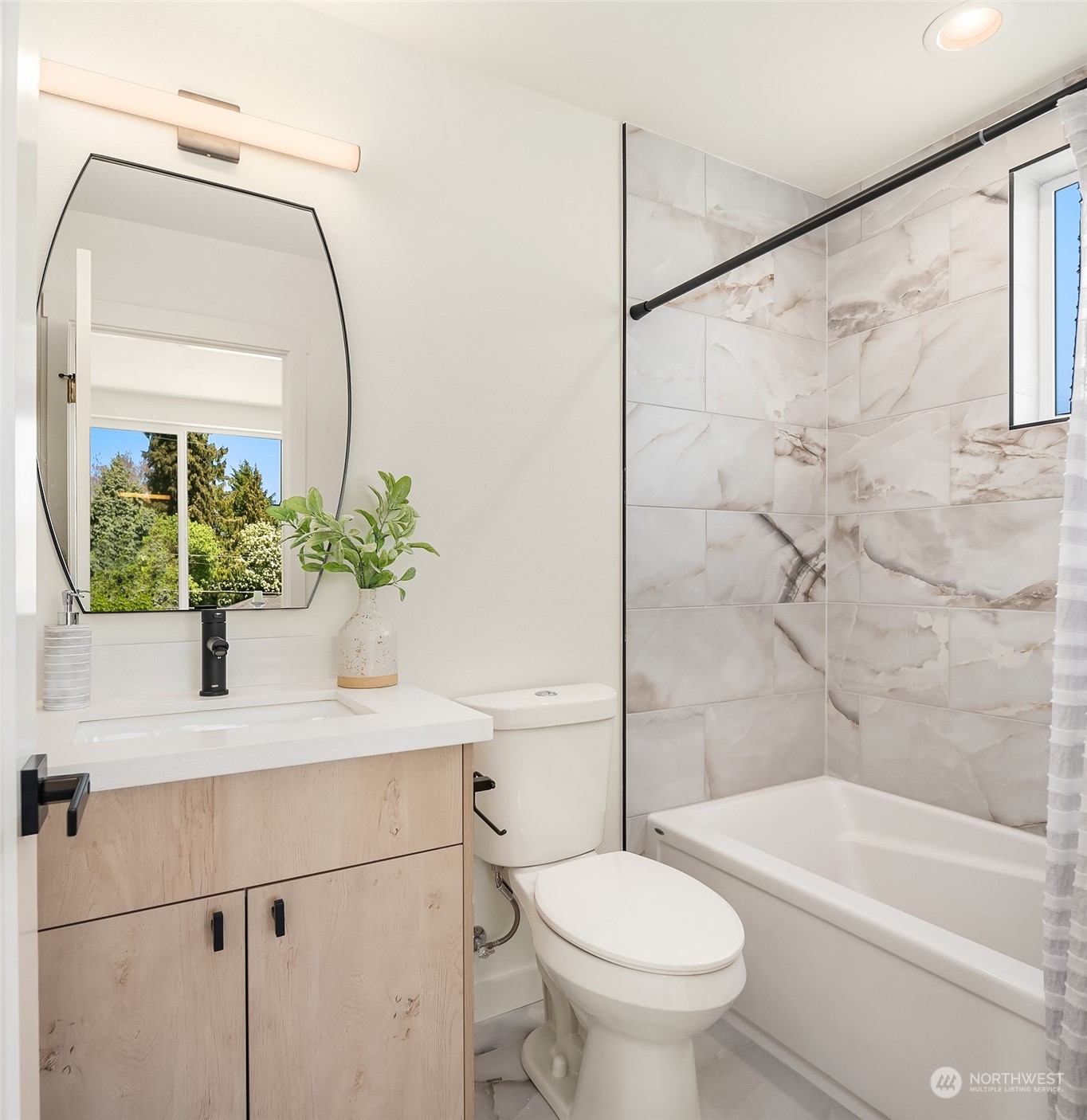 647 Northwest 54th Street, Unit A Seattle, WA 98107 - Photo 20 of 28 a bathroom with a sink a mirror a toilet and a bathtub