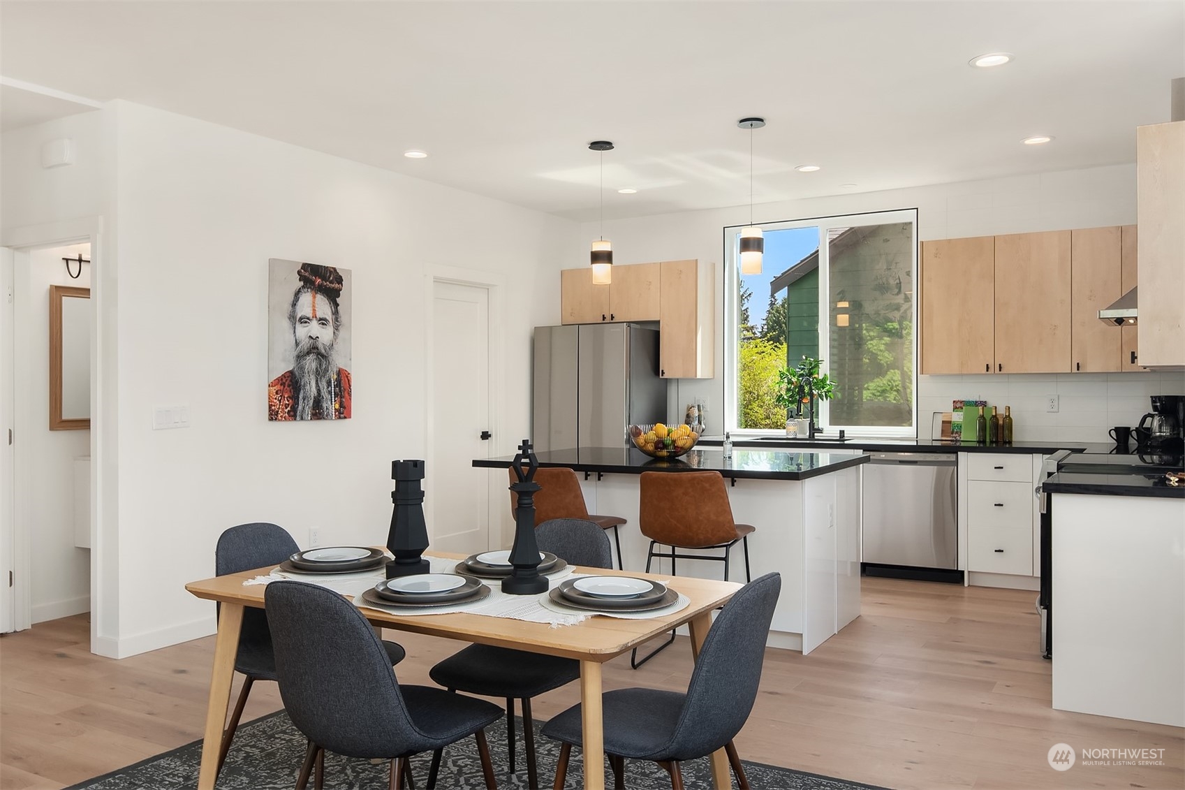 647 Northwest 54th Street, Unit A Seattle, WA 98107 - Photo 10 of 28 a kitchen with granite countertop a dining table chairs and white cabinets