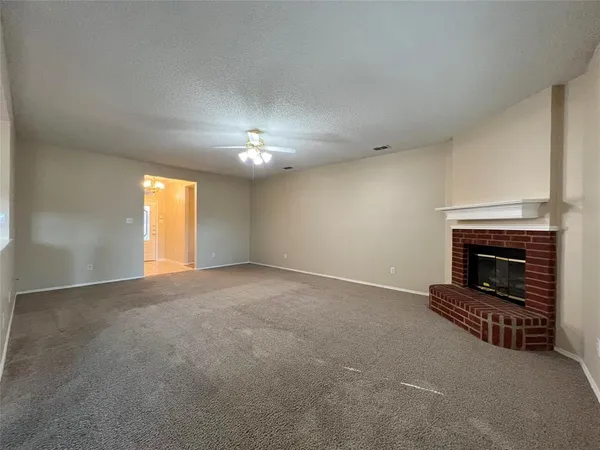 a view of an empty room with a fireplace and a window
