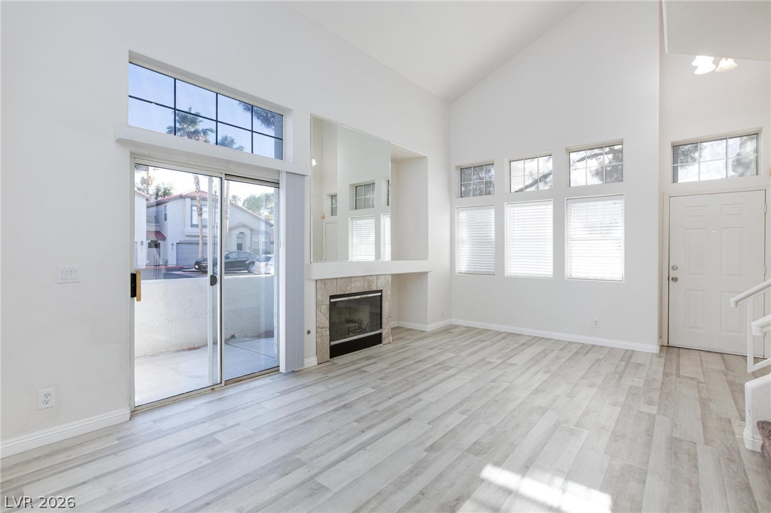 2246 Ramsgate Drive Henderson, NV 89074 - Photo 4 of 36 A spacious living area features light-toned flooring, high ceilings, and a cozy fireplace, opening to an outdoor patio.