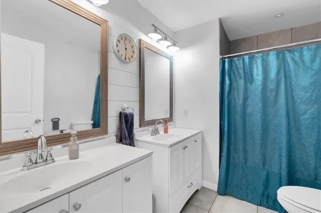 a bathroom with a sink vanity mirror and toilet